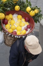 Istanbul, January 16th 2020 An old man carrying a basket of apples on his back, Istanbul, Turkey