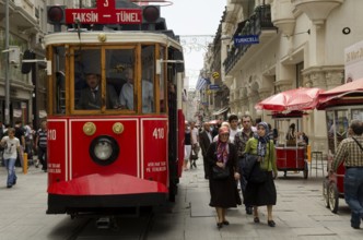 May 21st 2012. Istanbul, Turkey. Old Turkish women passing a traditional tram along Istiklal Street