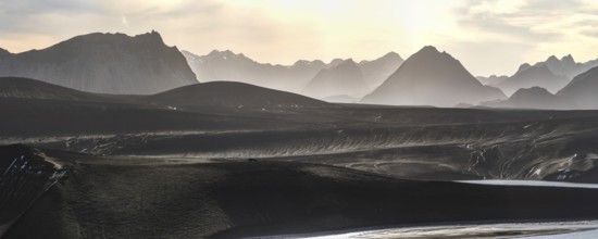 Captivating panoramic view of the Icelandic Highlands at sunset Mist gently blankets the mountains,