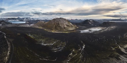 A breathtaking view of a volcanic mountain surrounded by lush green moss, winding rivers, and