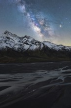 A stunning view of the Milky Way illuminating the serene, icy landscape of Iceland Snow-capped
