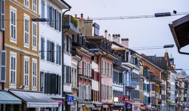 A vibrant street view of Rolle, Switzerland, showcasing colorful historic buildings with charming