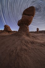Captivating night sky with star trails above unique sandstone formations in Goblin Valley State