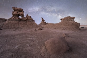 Under the vast night sky, unique sandstone formations of Goblin Valley State Park, Utah, create a