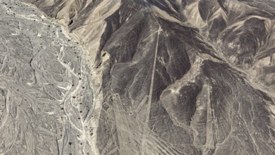 Aerial view of a desert landscape with complex line patterns and geoglyphs, the geoglyphs and