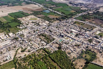 Aerial view of a city surrounded by agricultural land and a highly visible road network, The city