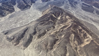 Mountain ranges in a dry desert landscape with clear geoglyph patterns, the geoglyphs and images in