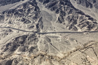 Dry, rocky desert landscape with lines and a highway, the geoglyphs and images in the desert near