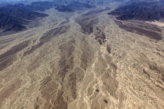 Impressive aerial view of a desert landscape with many earthy textures and furrows, central focus