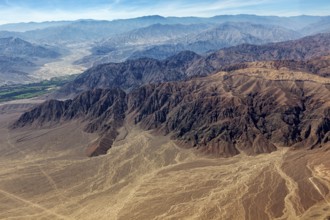 Impressive mountain formations in the midst of an extensive desert landscape from above, the desert