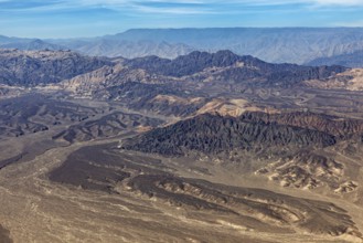 Crater-like hills in a vast desert landscape with blue sky, the desert landscape near Nasca in Peru