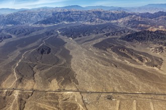 Extensive desert landscape with a long straight road, captured from above, The desert landscape