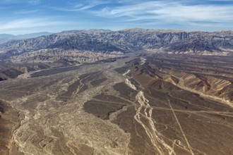 Barren desert plain with extensive mountains seen from a bird's eye view, the desert landscape near