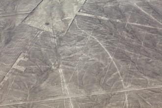 Aerial view of geometric figures in a dry desert landscape known as the Nazca Lines, the geoglyphs