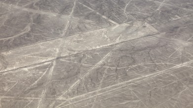 Aerial view of the Nazca lines in a barren desert landscape with geometric patterns, the geoglyphs