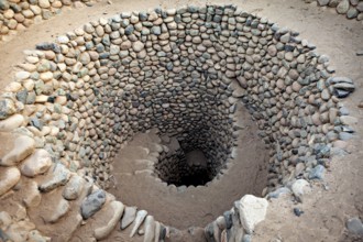 Tightly wound spiral of stones that reaches deep into the ground, The ancient Nazca wells (puquios)