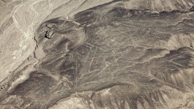 High-altitude view of a vast, dry landscape with linear structures, geoglyphs and drawings in the