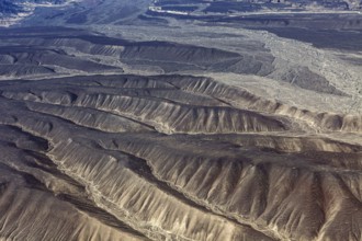 Aerial view of dry, folded mountains in a desert-like landscape, the desert landscape near Nasca in