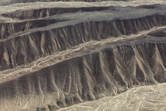 Aerial view of eroded hills in a desert landscape with brown earth tones, The desert landscape near