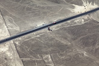 View of a road leading through a desert landscape with geoglyphs, the geoglyphs and paintings in