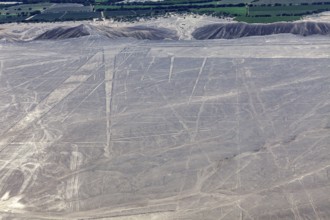 View of the desert with visible geoglyphs, fields and mountains lying in the distance, the