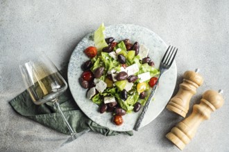 A vibrant Greek salad featuring juicy tomatoes, crisp lettuce, feta cheese, and red olives, paired