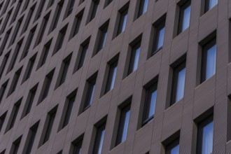 A detailed view of a modern building facade featuring a repetitive geometric pattern with aligned