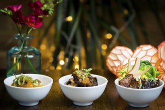 Trio of gourmet dishes, tempura mushrooms in curry sauce, aubergine stew over rice, and roasted