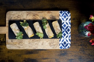 Delicious vegetable and courgette rolls elegantly arranged on a decorative wooden platter with
