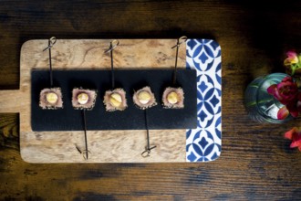 A top view of seared tuna skewers, with mayonnaise on an elegant platter The arrangement is