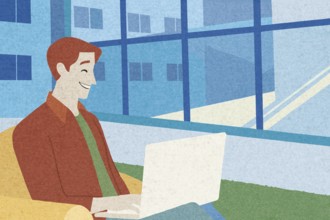 A man sits comfortably on a couch in a modern workspace, smiling while using his laptop The large