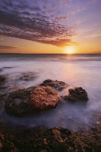 A breathtaking sunset scene at Cabo Roig, Orihuela Costa, Alicante, with vibrant colors reflecting