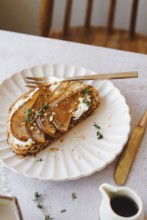 Top view of a delicious pear toast garnished with thyme, honey drippings, and crumbled cheese,