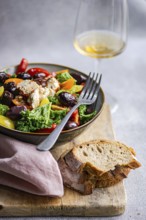 Salad features fresh raw kale, assorted cherry tomatoes, crisp red onion slices, BBQ olives, and