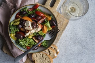 Top view of a nutritious kale salad mixed with vibrant cherry tomatoes in various colors, thinly