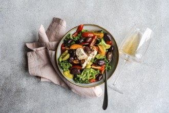 Top view of a vibrant healthy salad featuring raw kale leaves, a mix of colorful cherry tomatoes,