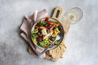 Top view of a salad featuring raw kale, assorted cherry tomatoes, red onion slices,