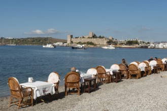 Bodrum, Mugla, Turkey. April 21st 2022 Restaurant Tables on the beach in Bodrum harbour with Bodrum
