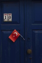 Bodrum, Mugla, Turkey. April 23rd 2022 A pretty blue door with a Turkish flag in the charming side
