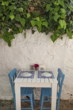 Pretty blue and white cafe restaurant table in a shaded side street in the popular tourist