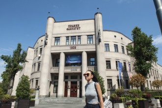 Belgrade, Serbia. July 23rd 2019 A pretty young Serbian girl walks past a soviet era building in