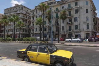 A black and yellow Alexandrian taxi parked along the Mediterranean Sea front Corniche, Alexandria,