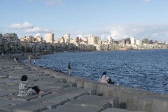 Alexandria, Egypt. December 1st 2022 Egyptian people on concrete blocks positioned as a defence