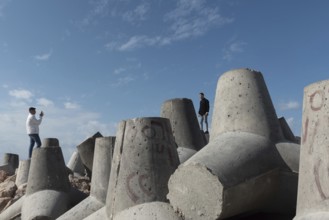 Alexandria, Egypt. December 1st 2022 Young Egyptian men take photographs on massive concrete blocks