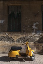 Trendy yellow motor scooter parked in a side street in the Mediterranean Egyptian city of