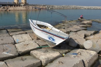 Alexandria, Egypt. December 1st 2022 Wooden boat abandoned on large concrete slabs designed to