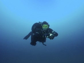 A diver in full gear floats in deep blue water. Giuseppe Dezza wreck dive site, Pula, Croatia,