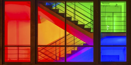 View through the windows of a brightly lit staircase. Frankfurter Mainova AG building, city center,