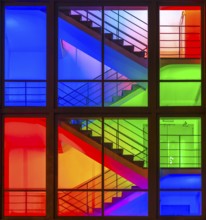 View through the windows of a brightly lit staircase. Frankfurter Mainova AG building, city center,