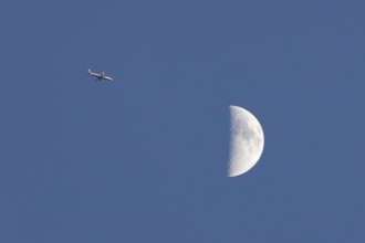 Airbus commercial passenger airliner jet aircraft of British airways in flight with the moon in the